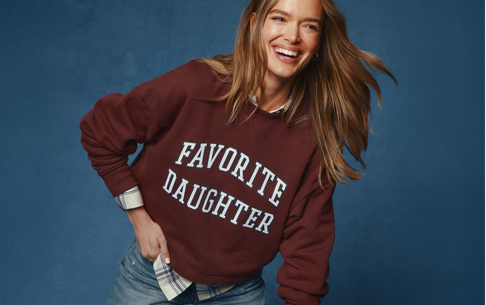 Image of woman wearing a Favorite Daughter graphic sweatshirt