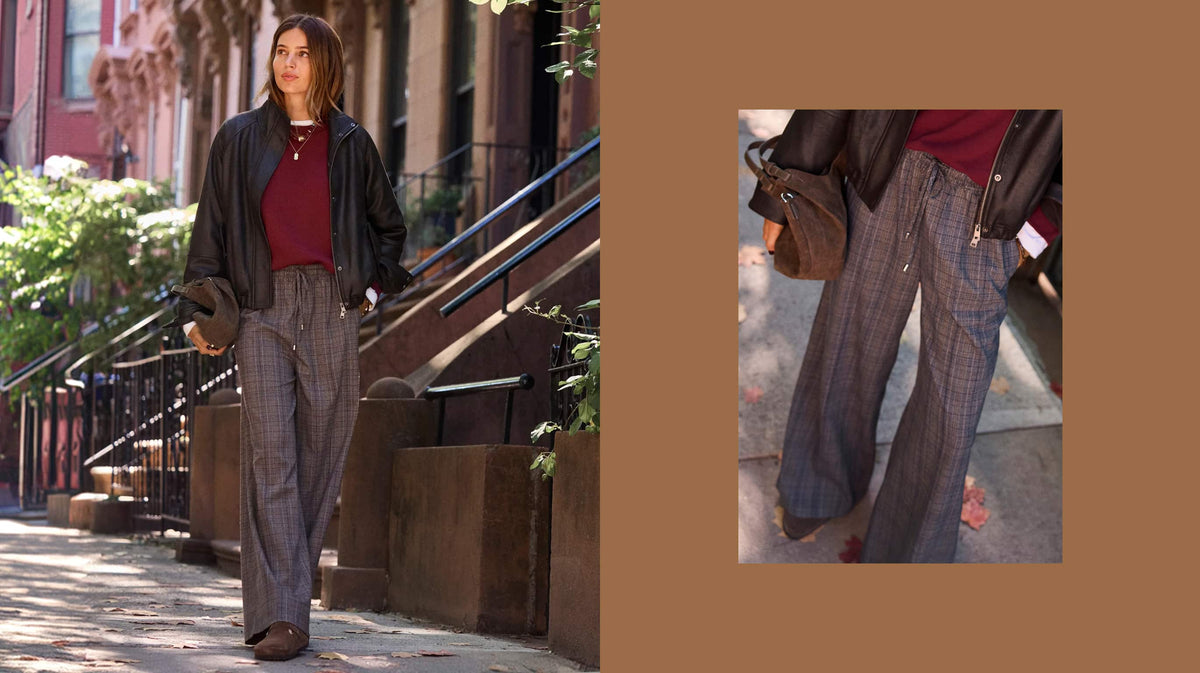 Woman wearing a burgundy sweater with a black bomber jacket and plaid pull-on pants.