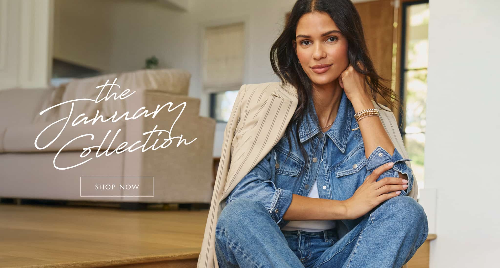 A woman models the January collection, wearing a striped blazer over a denim shirt and jeans.