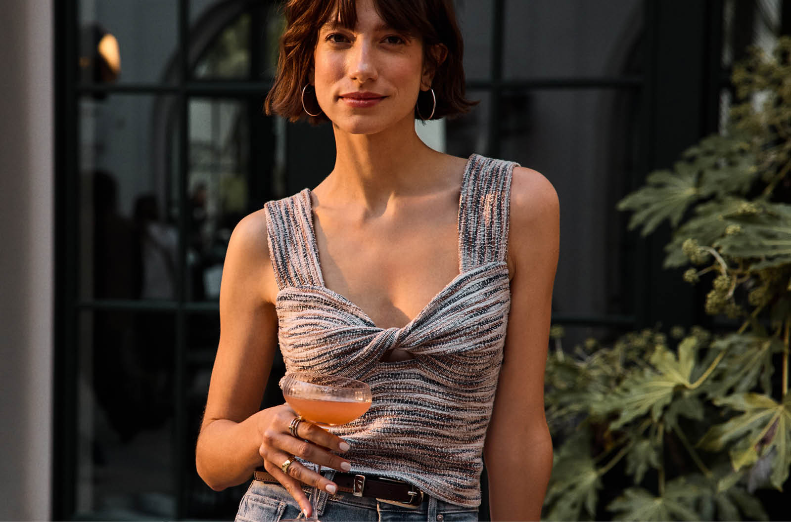 Image of woman wearing a twist front tank and jeans
