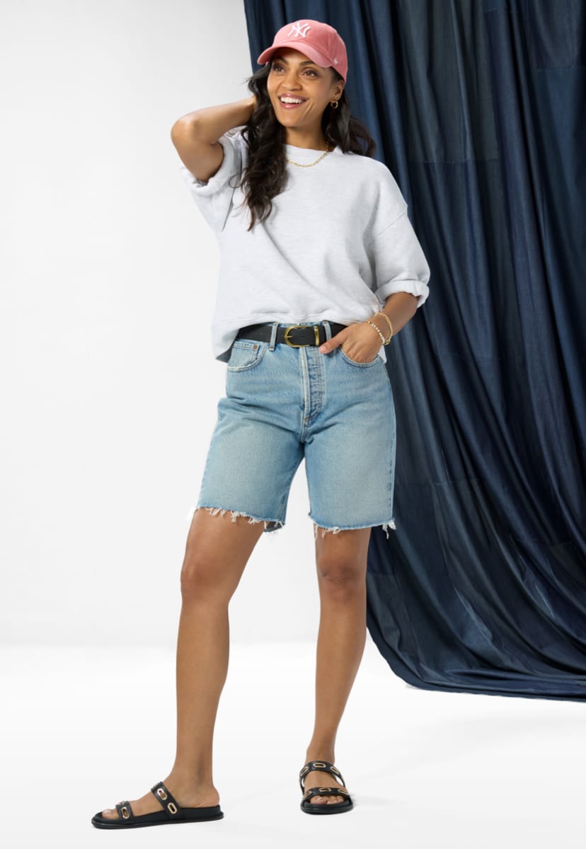 Image of woman wearing mid length denim shorts