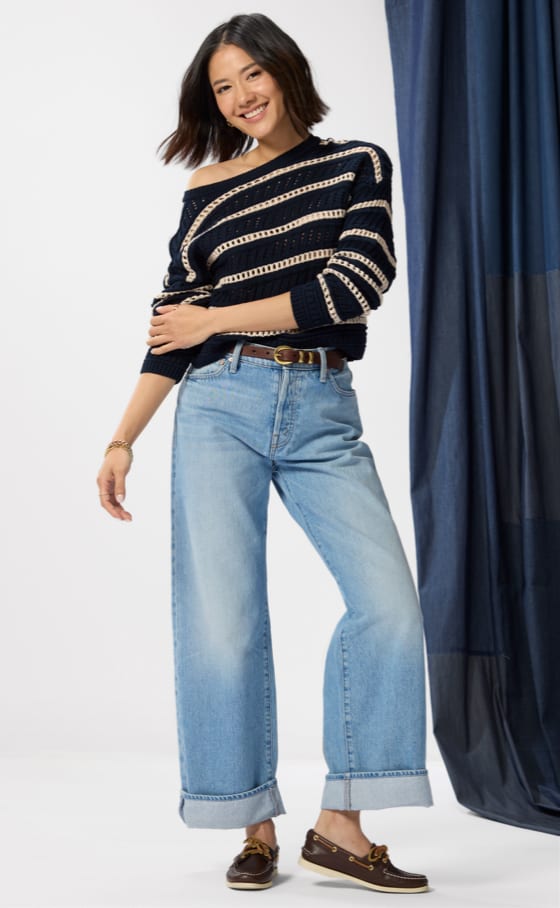 Image of woman wearing petite wide leg jeans with a cuff.