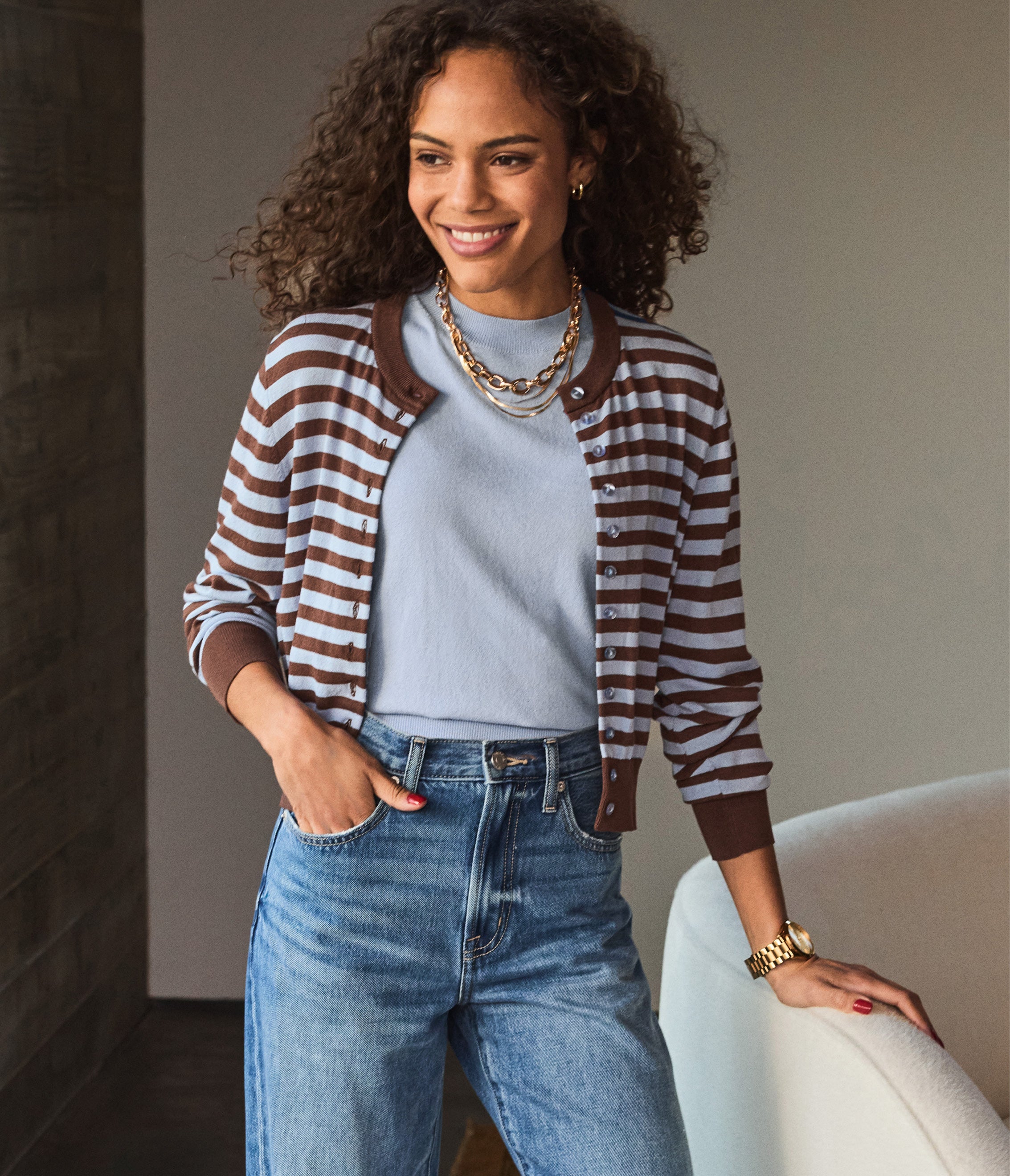Image of a woman wearing a stripe cardigan over a matching blue top
