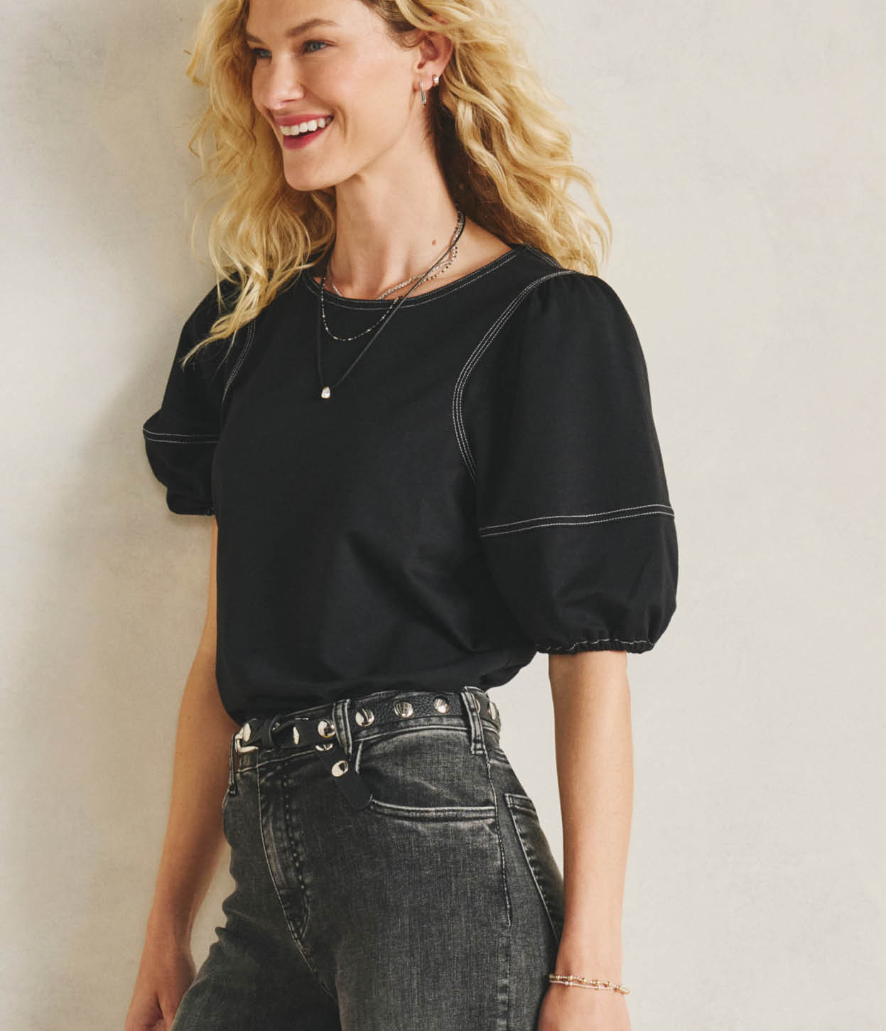 Image of woman wearing a black puff sleeve top with jeans