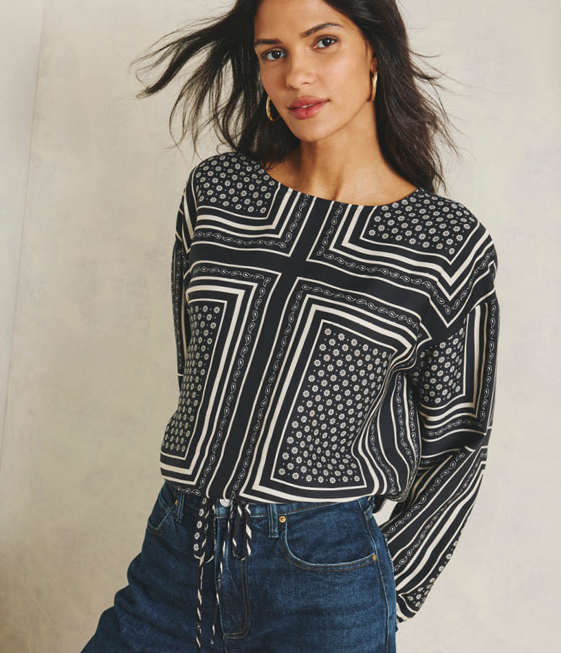Image of woman wearing a geo print blouse with jeans