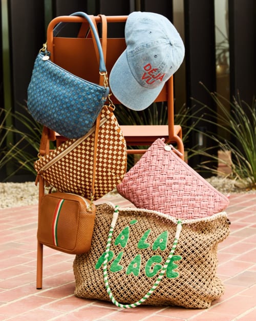 Image of several handbags and a baseball hat by the Clare V. brand.