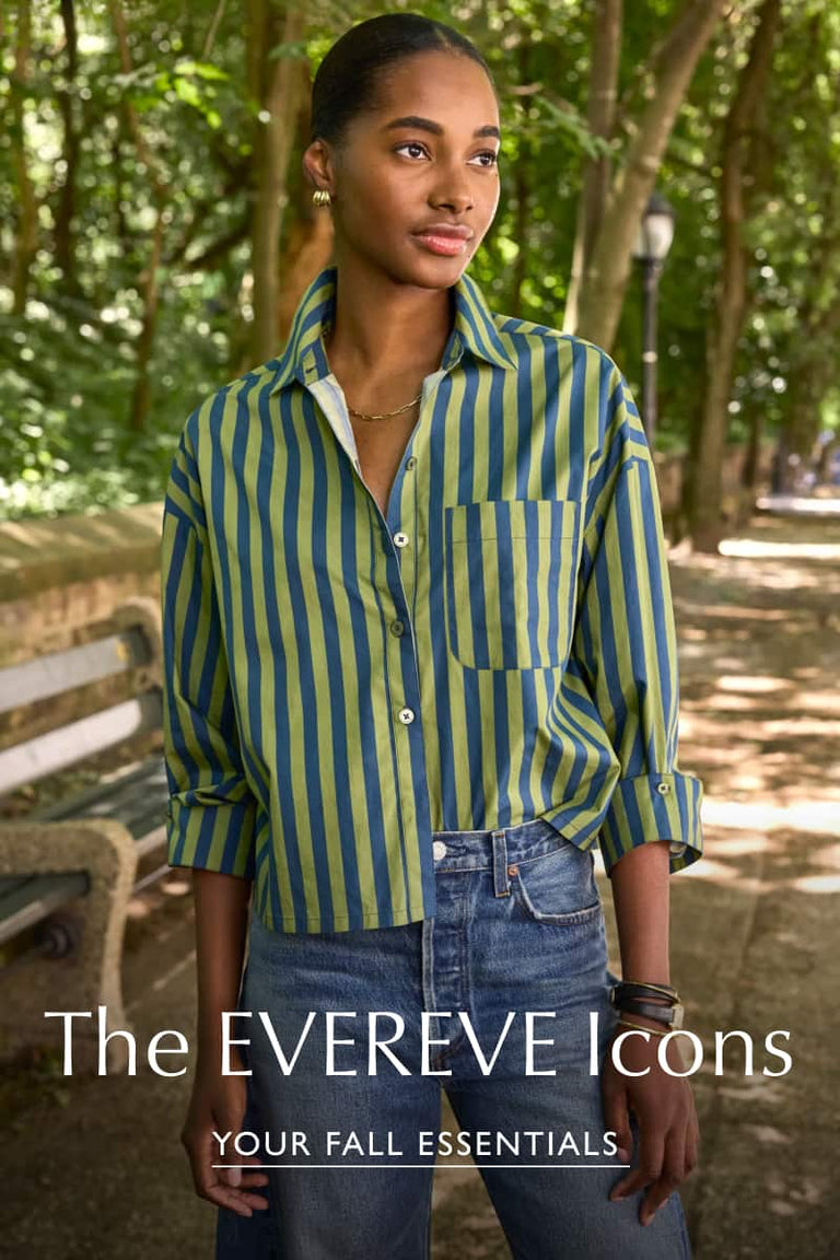Woman wearing green and blue striped button down shirt with blue jeans and gold earrings