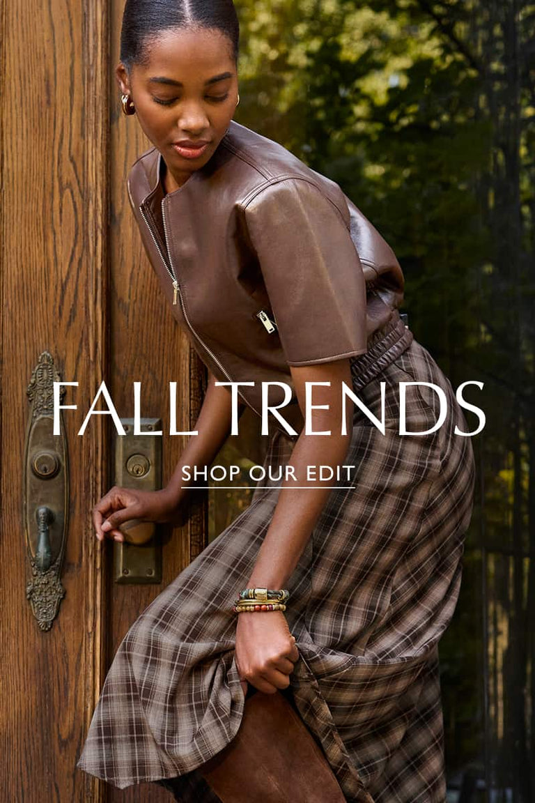 Woman wearing brown short sleeve leather bomber jacket with a plaid skirt