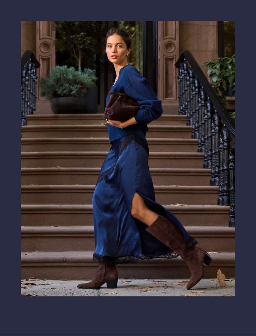Woman wearing a cobalt blue cashmere sweater with a blue satin skirt with black lace trim.