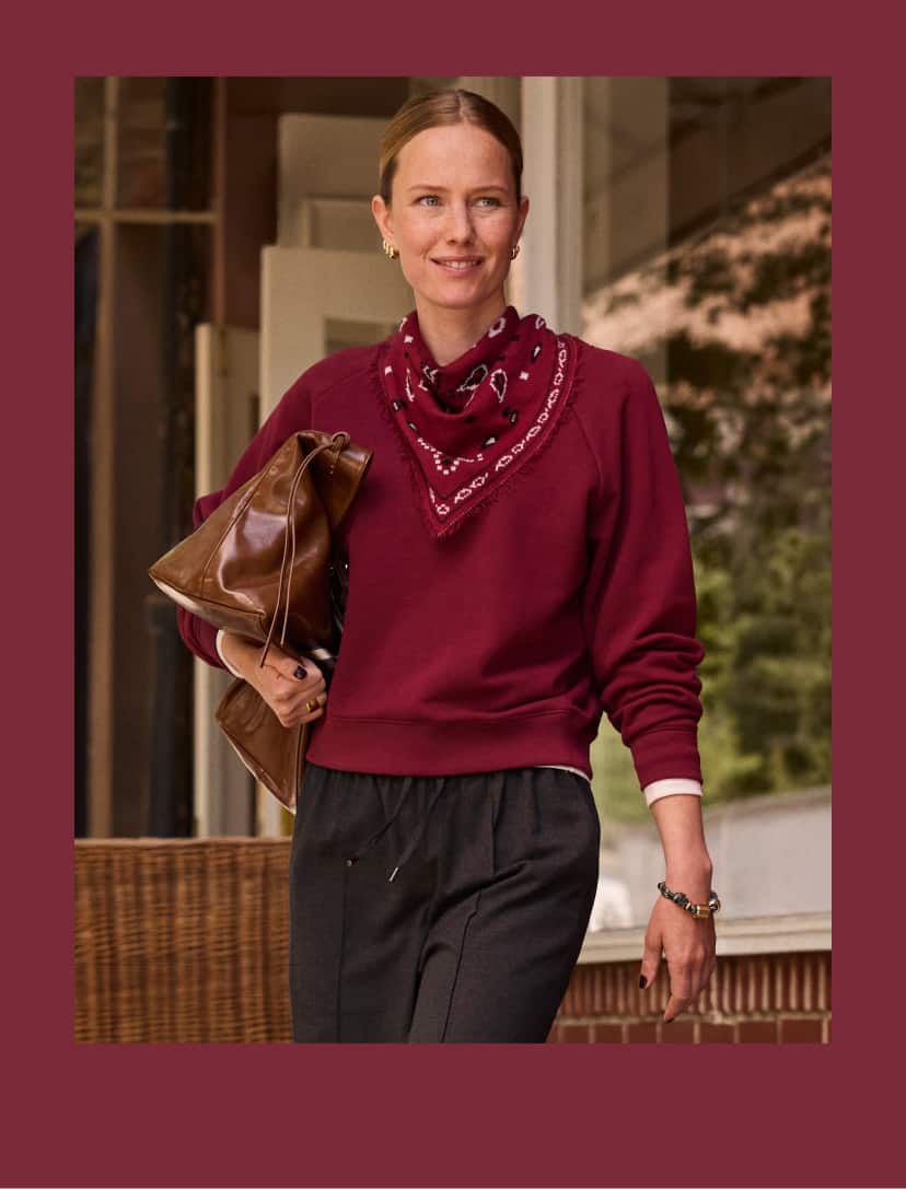 Woman wearing a burgundy sweatshirt with bandana scarf and pull on pants. 