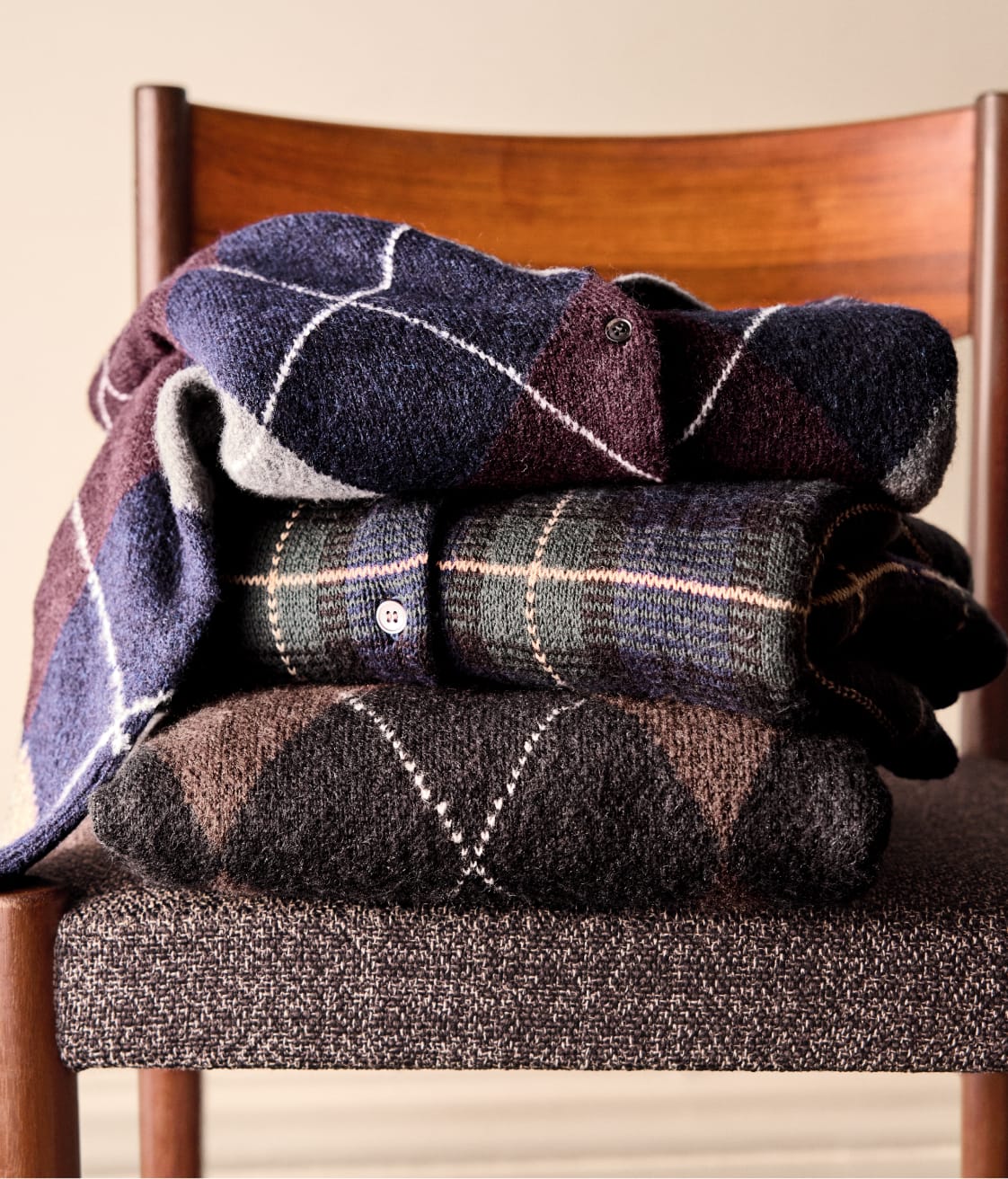 Image of a stack of plaid sweaters folded on a chair