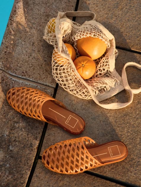 Image of jelly sandals next to a bag of oranges