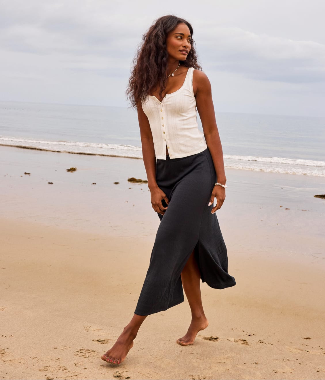 Image of woman on the beach wearing white tank and black maxi skirt