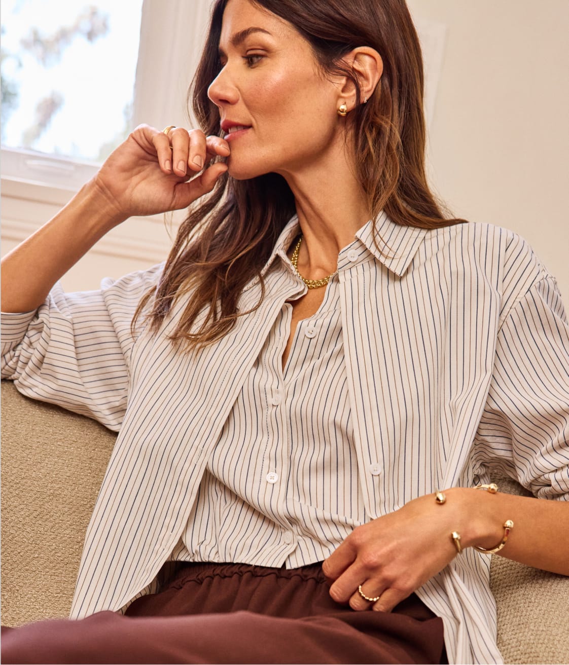 Woman wearing a striped button-down top with brown pants
