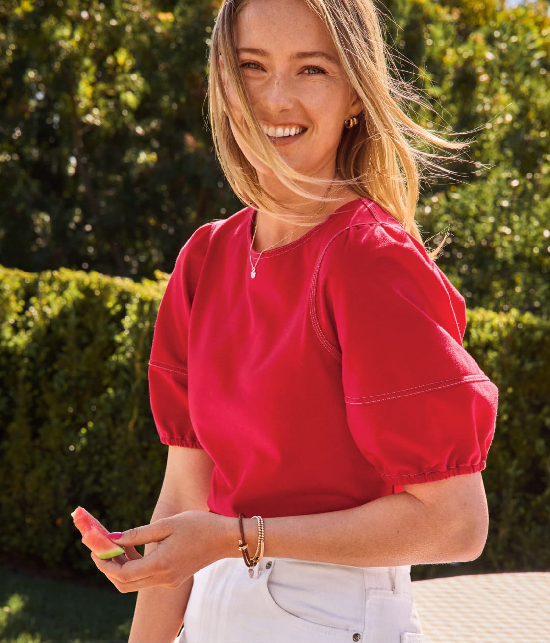 Image of woman wearing a red short sleeve top with white shorts