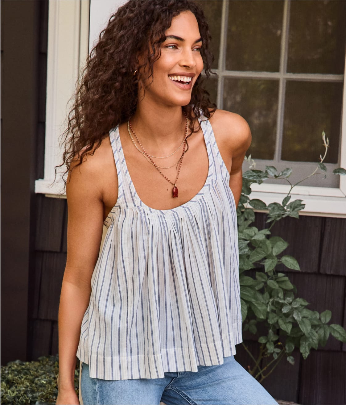 Image of woman wearing brown studded tank with black shorts.