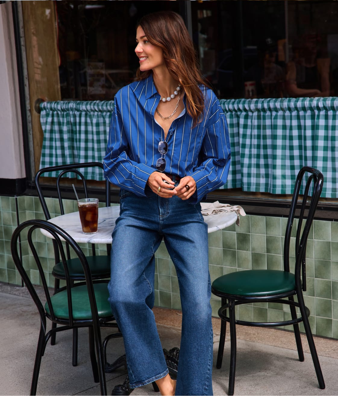 Woman wearing a blue button-down top with jeans