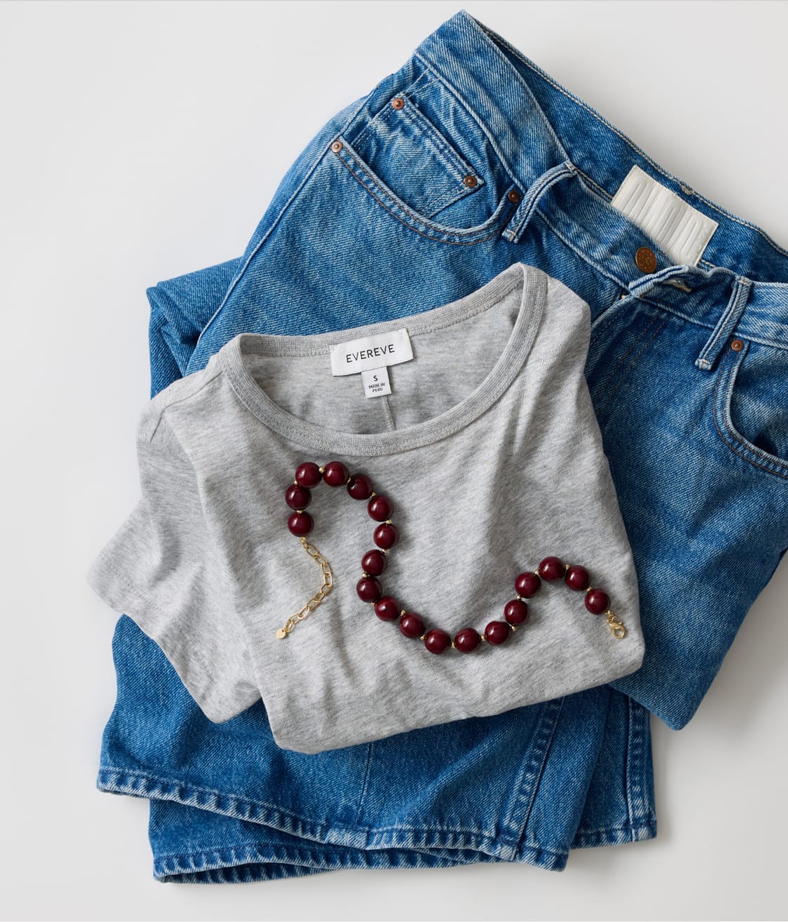 Grey tee with blue heans and a burgundy beaded necklace