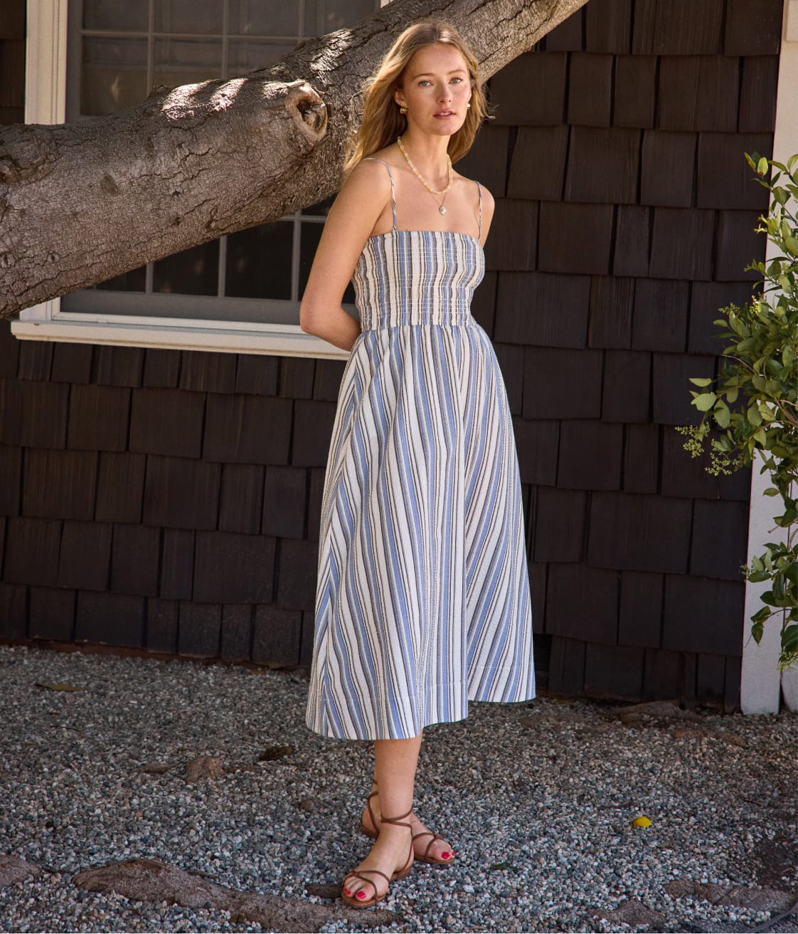 Image of woman wearing a satin cami with ivory jeans