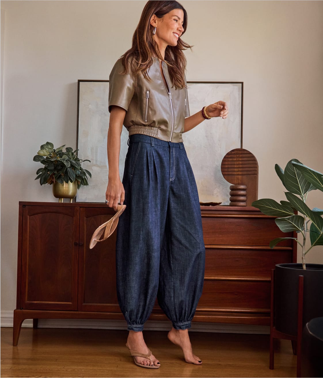 Woman wearing a short sleeve bomber jacket with balloon style jeans