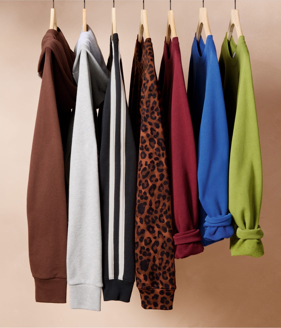 Image of several colorful EVEREVE sweatshirts hanging on a rack.