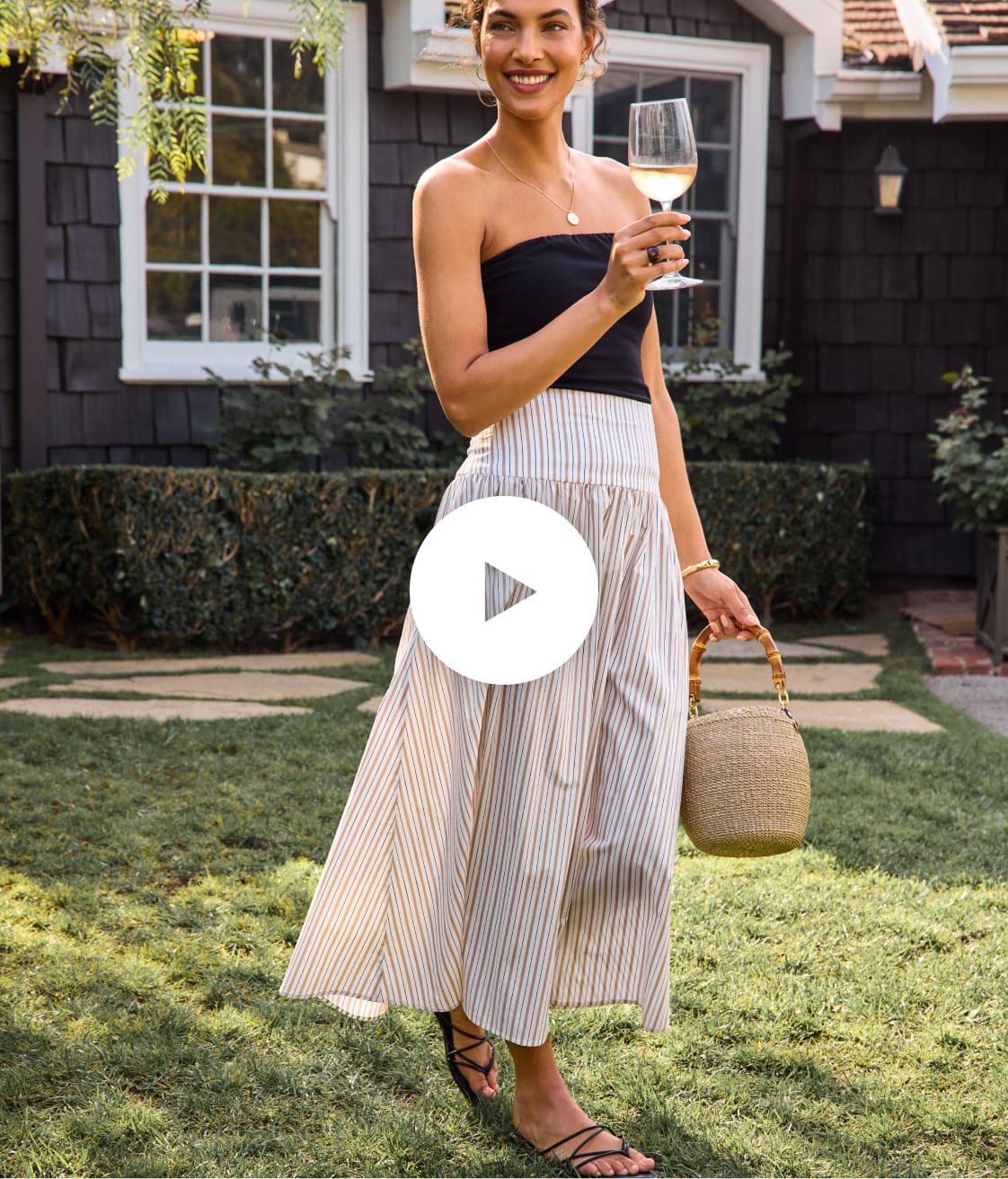 Image of woman wearing a black tube top with striped maxi skirt