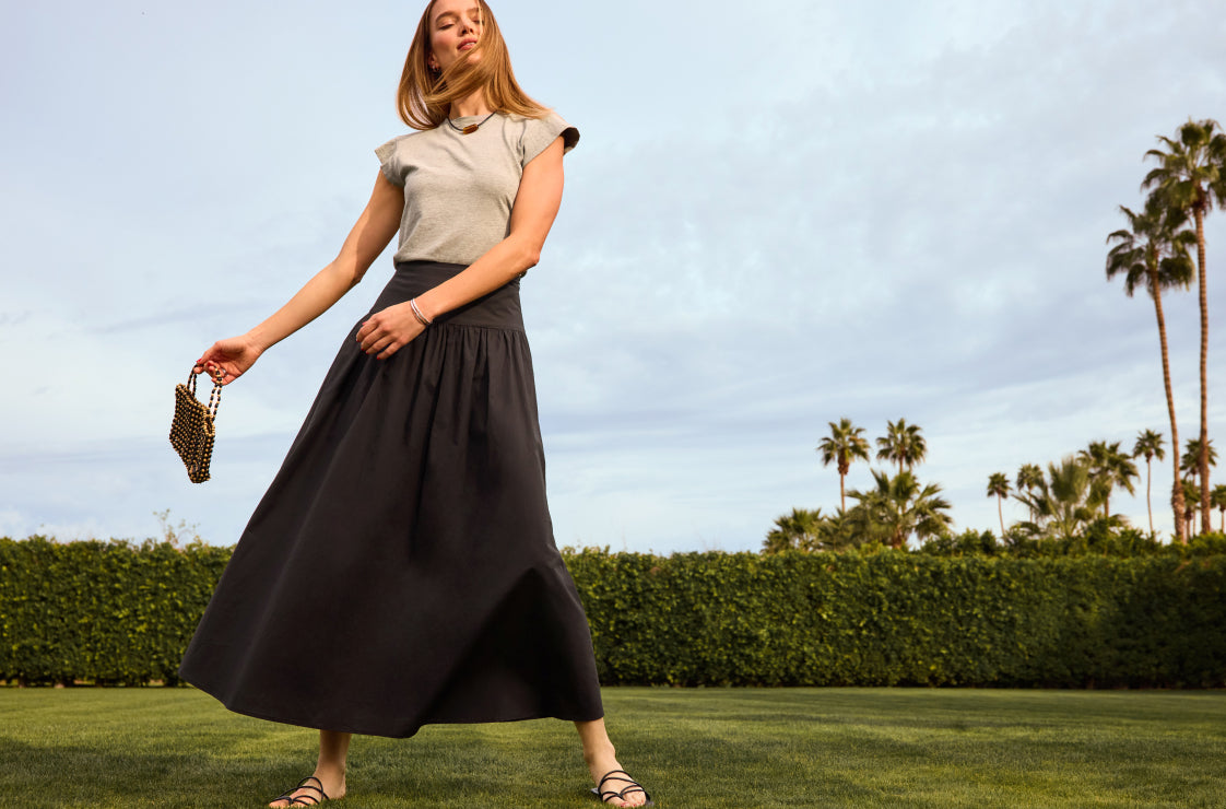 Image of woman wearing a black maxi skirt and grey tee