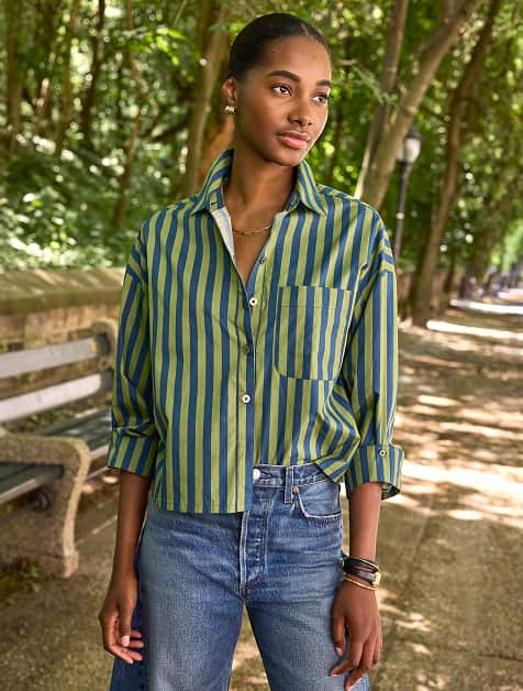 Woman wearing a green striped button down shirt and jeans
