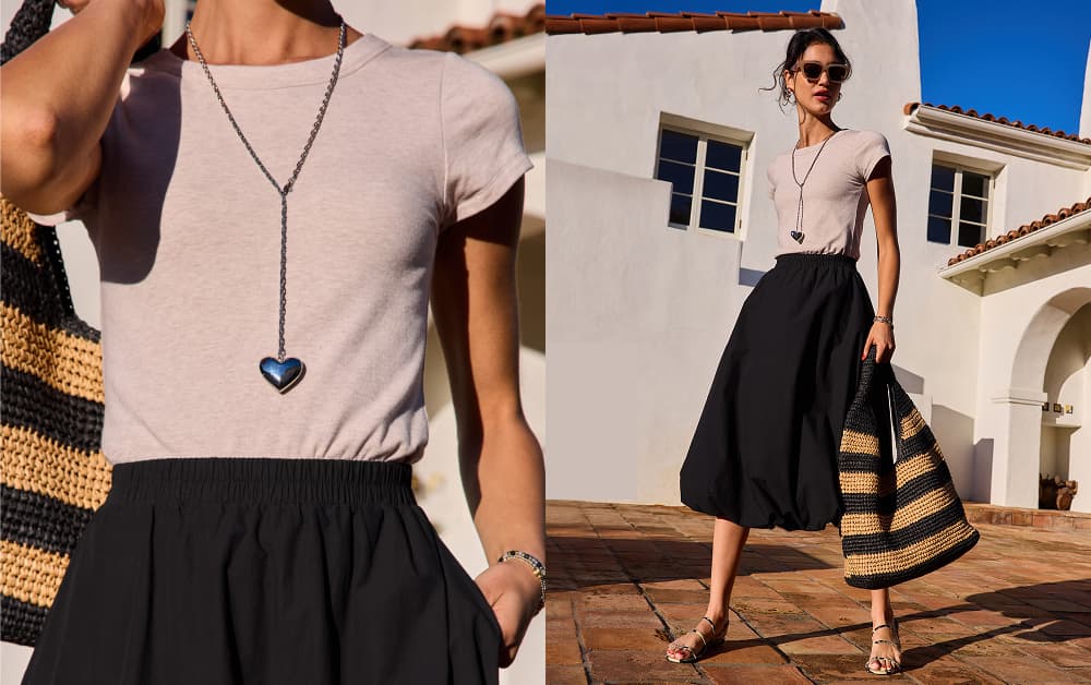 Image of woman wearing a tan tee with a black bubble hem skirt and a heart pendant necklace