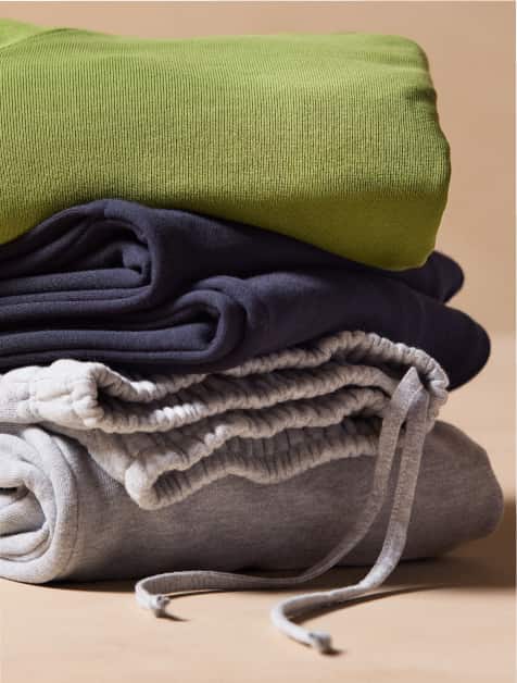 Image of a stack of folded sweatpants and sweatshirts