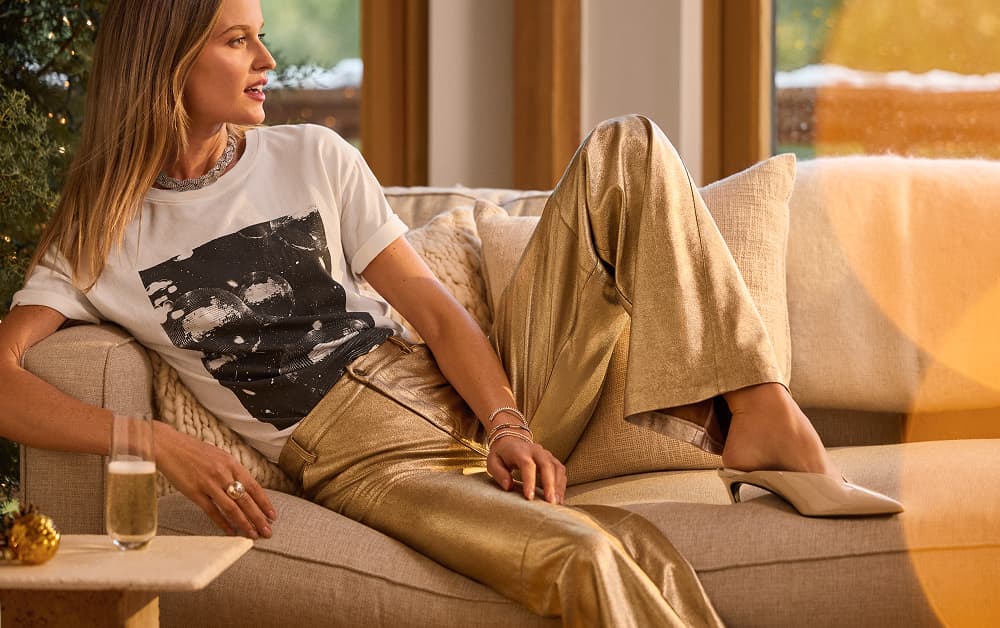 Image of woman wearing graphic tee and metallic gold pants
