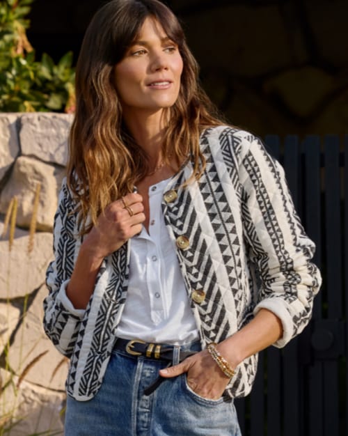 Image of woman wearing a printed coat and jeans.