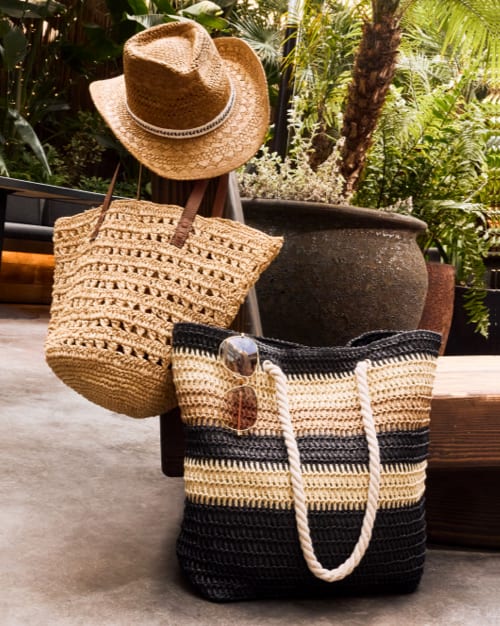 Image of two woven tote bags and a woven straw hat.